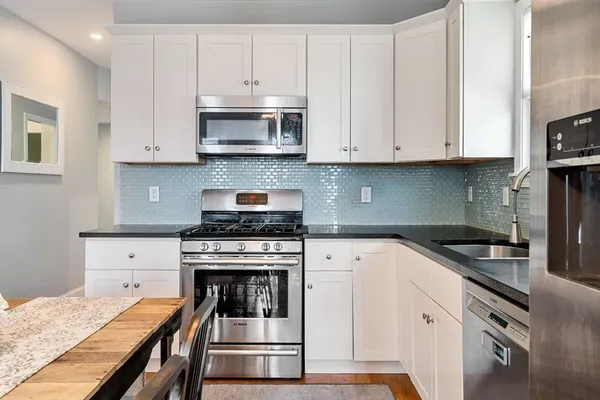 a kitchen with granite countertop a stove sink and cabinets