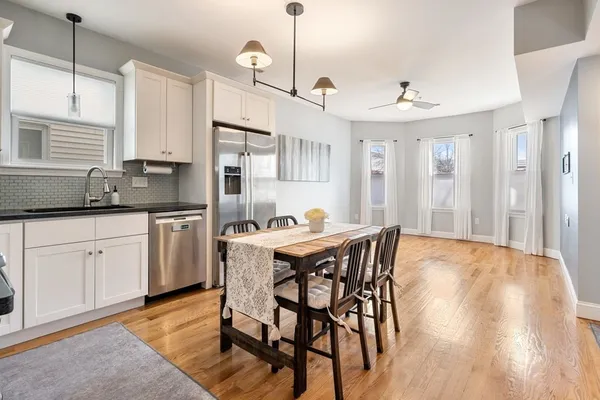 a kitchen with a table chairs refrigerator and cabinets