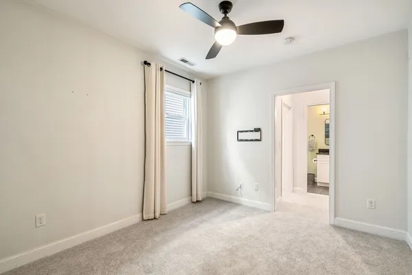 an empty room with fan and entrance