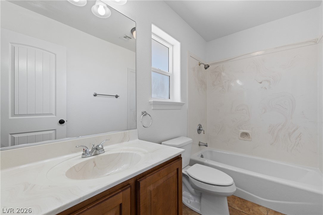 575 Gann Avenue Logandale, NV 89021 - Photo 48 of 75 A pristine full bathroom offers a modern vanity and a bright window above the toilet.
