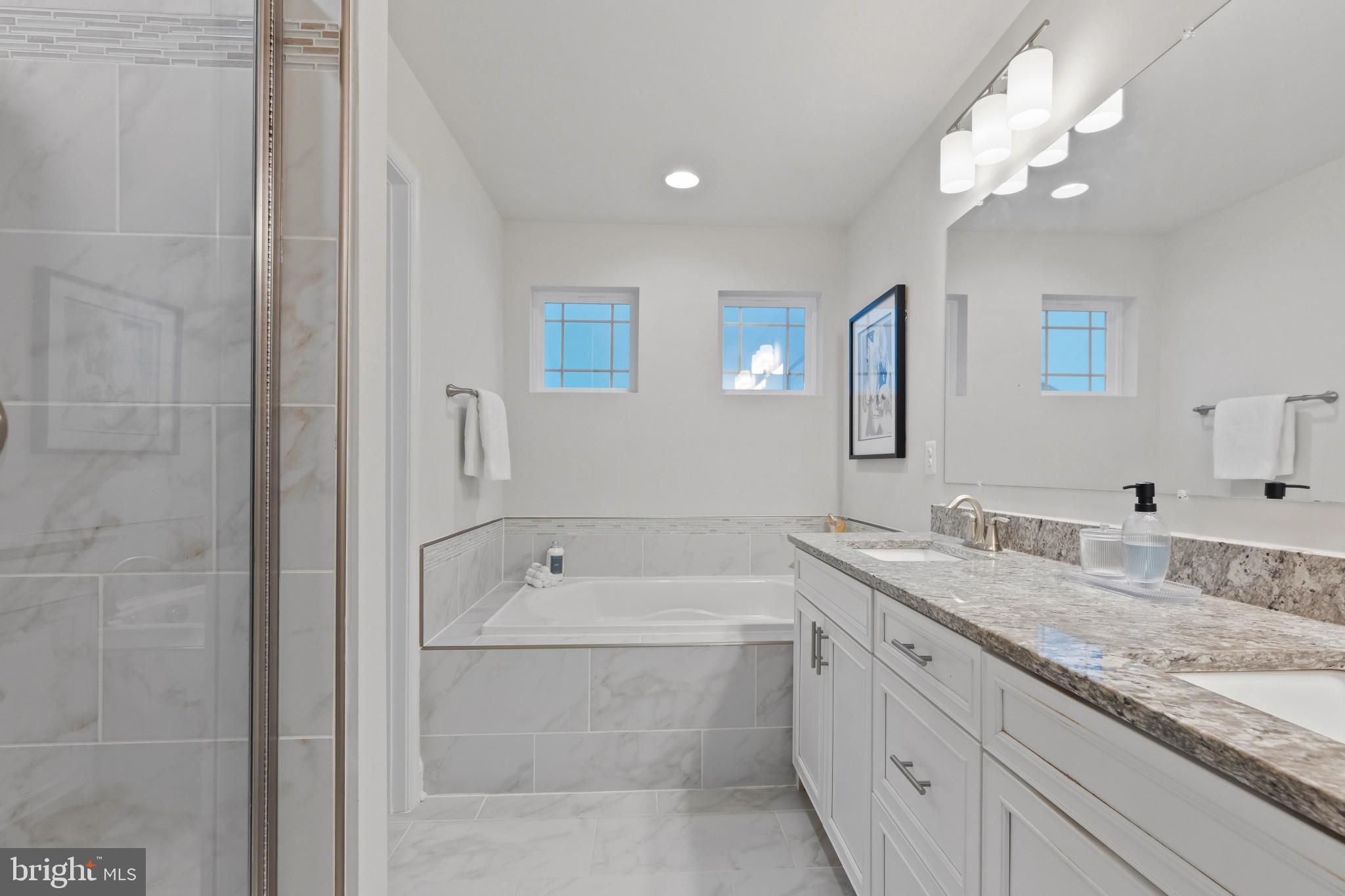 703 Perception Way Aberdeen, MD 21001 - Photo 17 of 42 a bathroom with a granite countertop sink a large mirror and a bathtub