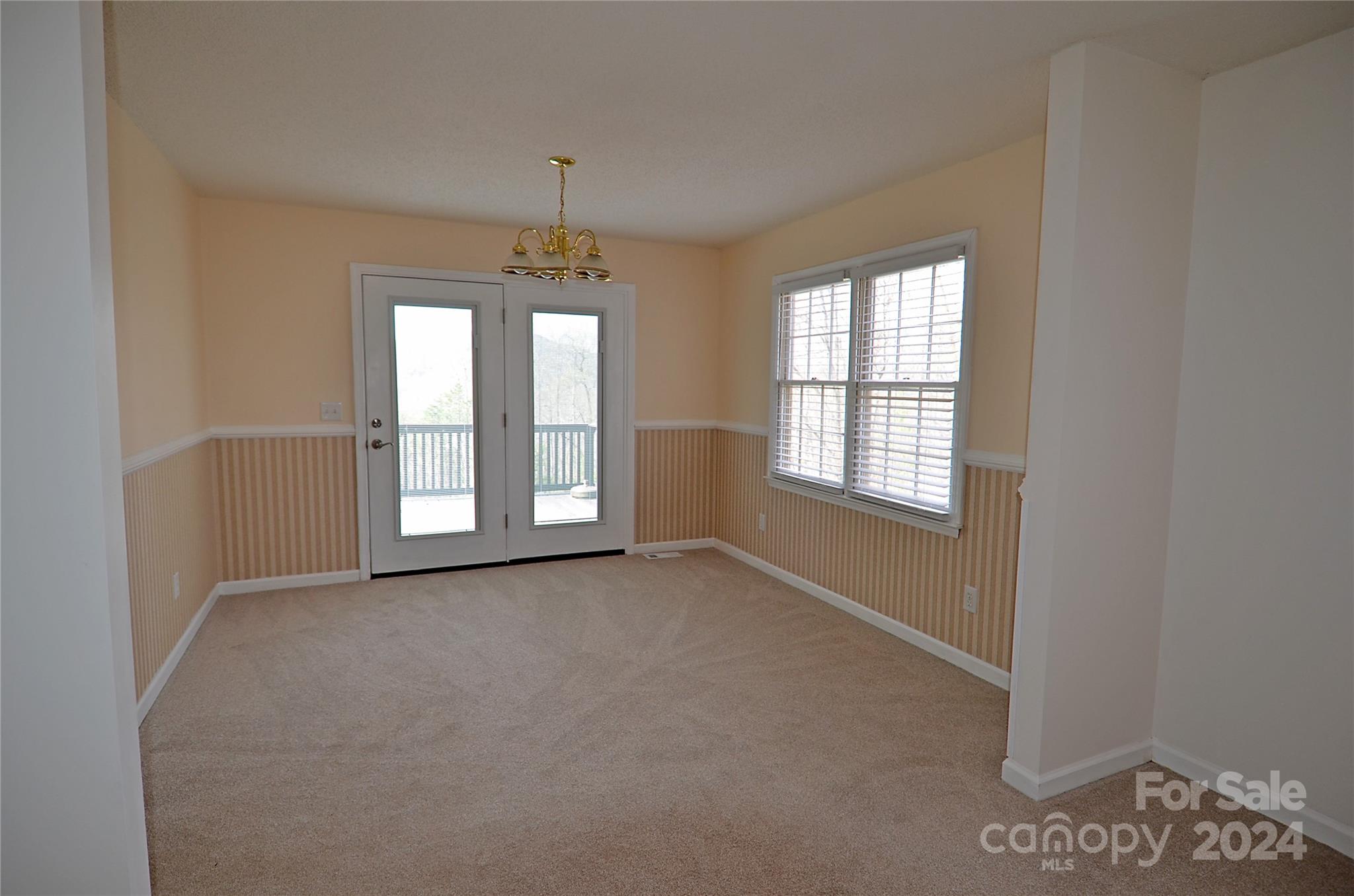 322 Cobblestone Drive Marion, NC 28752 - Photo 10 of 26 an empty room with windows and chandelier