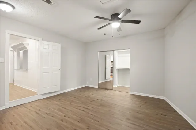 a view of an empty room with wooden floor