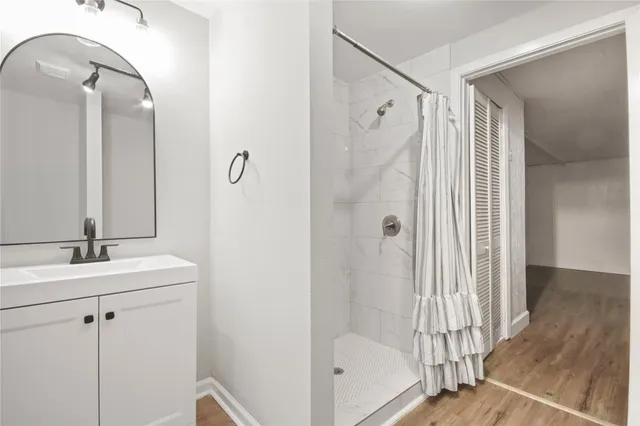 a bathroom with a shower sink and mirror