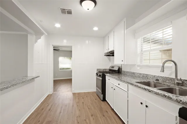 a kitchen with a sink cabinets stainless steel appliances and window