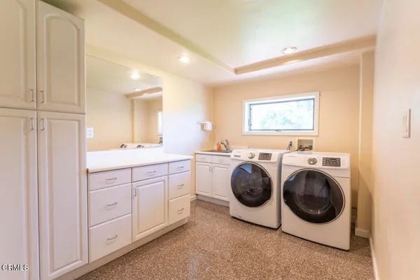 a utility room with sink dryer and washer