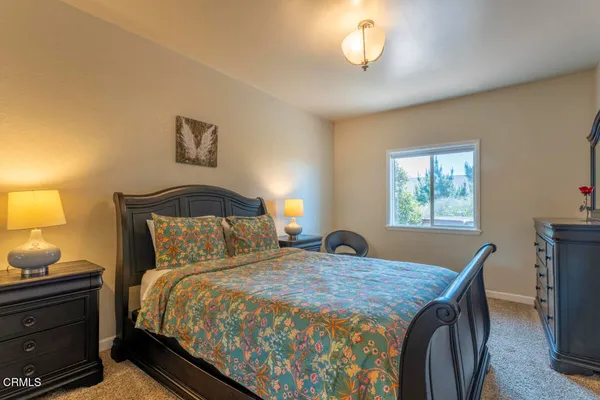 a bedroom with a bed and a lamp next to a window