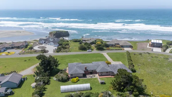 an aerial view of a house with garden space and ocean view