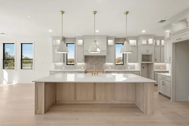 a large kitchen with kitchen island a large island in it