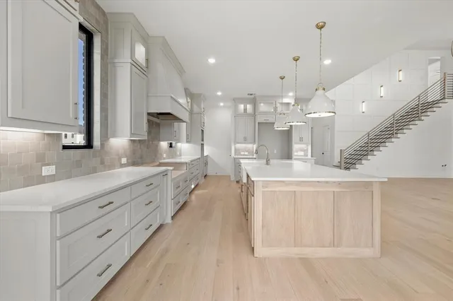 a large white kitchen with lots of counter space and a sink