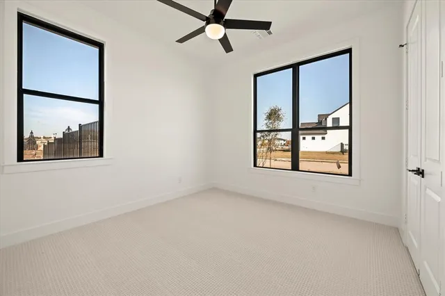 an empty room with a window and a ceiling fan