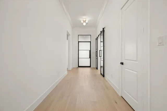 a view of a hallway with wooden floor and cabinet