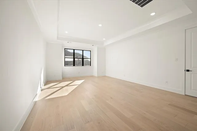 an empty room with a window and a ceiling fan