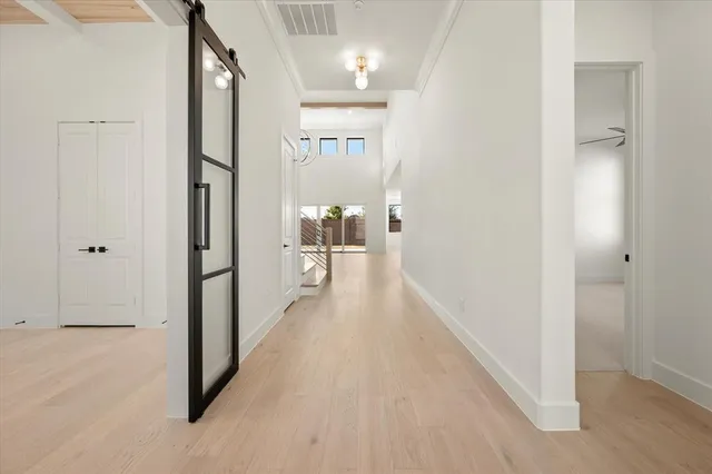 a view of a hallway with wooden floor and closet area