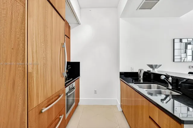a kitchen with granite countertop a sink and a stove top oven