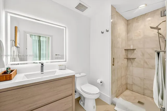 a bathroom with a sink toilet a mirror and shower