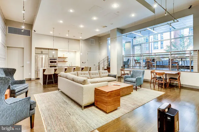 a living room with furniture kitchen view and a large window