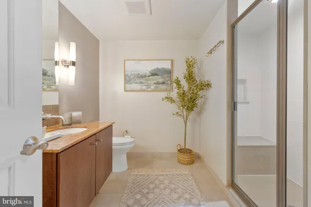a bath room with a toilet a sink and mirror