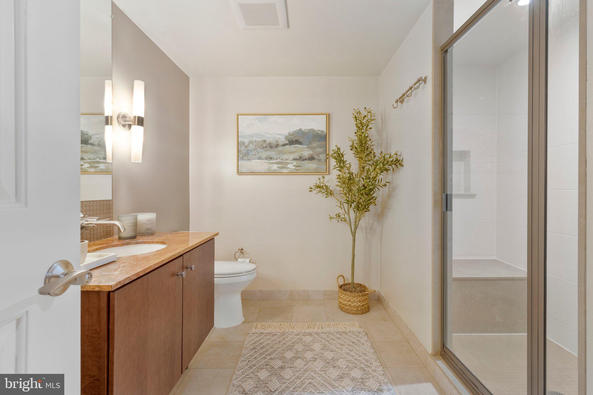 1025 First Street Southeast, Unit 907 Washington, DC 20003 - Photo 8 of 22 a bath room with a toilet a sink and mirror