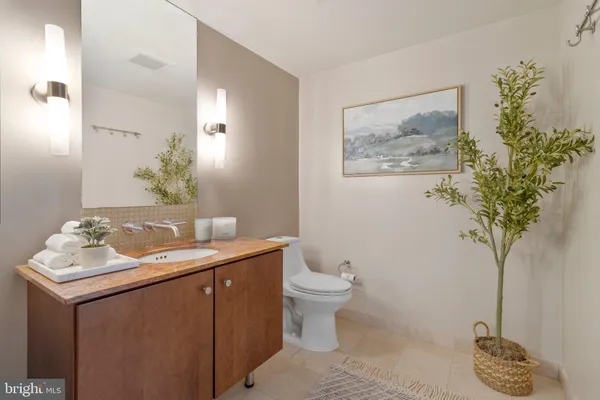a bathroom with a granite countertop sink a toilet and mirror