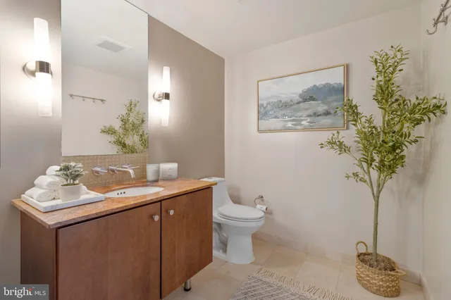 a bathroom with a granite countertop sink a toilet and mirror