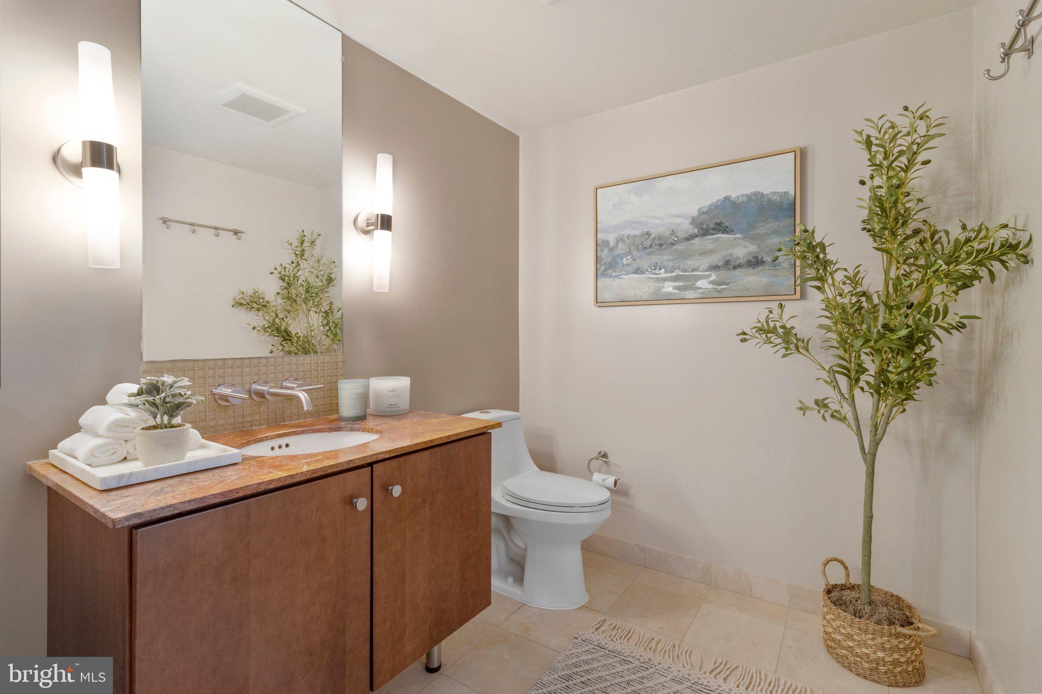 1025 First Street Southeast, Unit 907 Washington, DC 20003 - Photo 9 of 22 a bathroom with a granite countertop sink a toilet and mirror