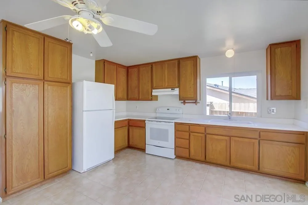 12941 Standish Drive Poway, CA 92064 - Photo 12 of 30 a kitchen with cabinets a window and stainless steel appliances
