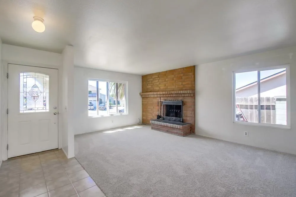12941 Standish Drive Poway, CA 92064 - Photo 5 of 30 an empty room with windows and fireplace