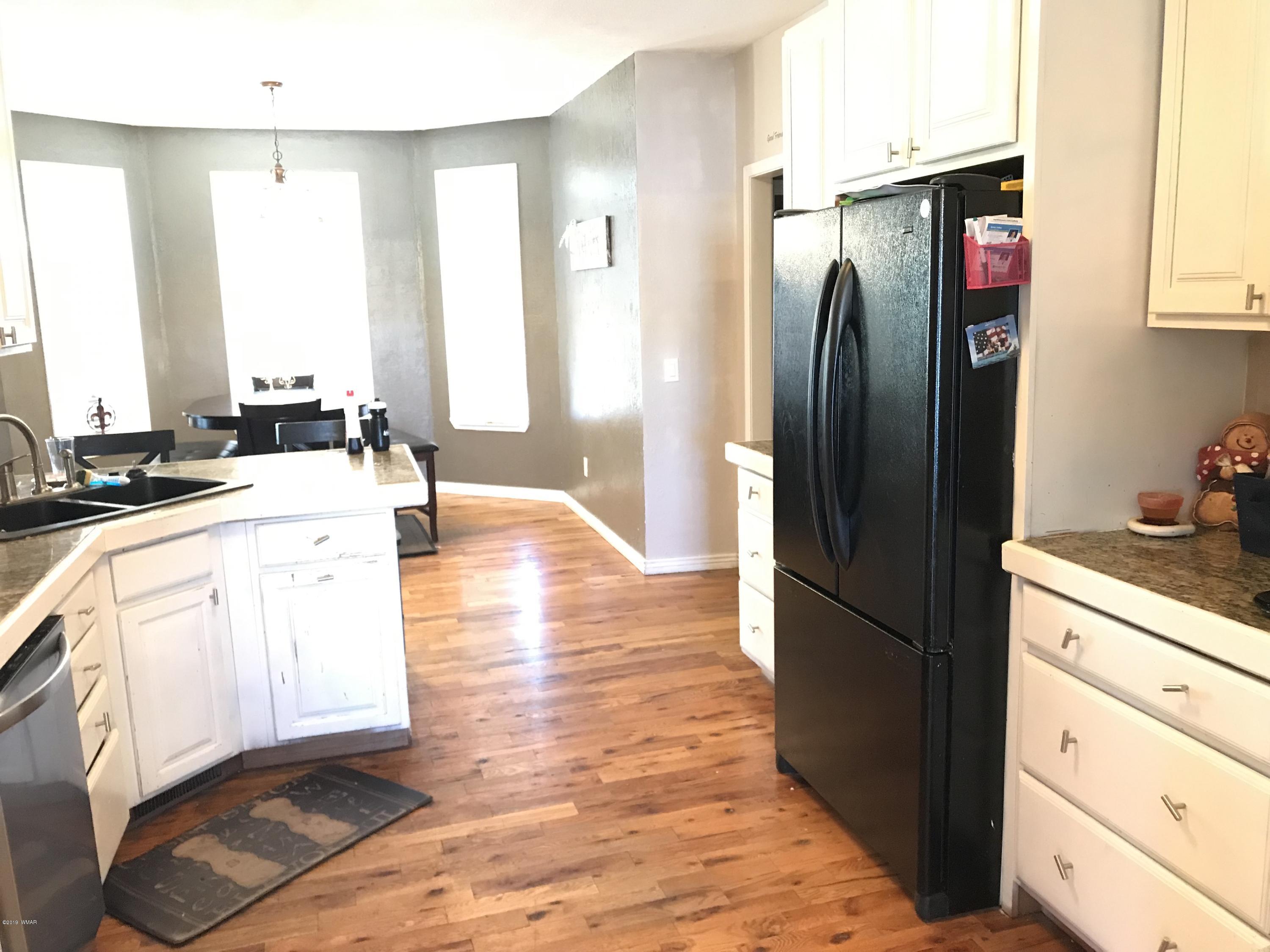 1362 Lobo Trail Snowflake, AZ 85937 - Photo 7 of 34 a kitchen with stainless steel appliances granite countertop a refrigerator a stove and a sink with wooden floor