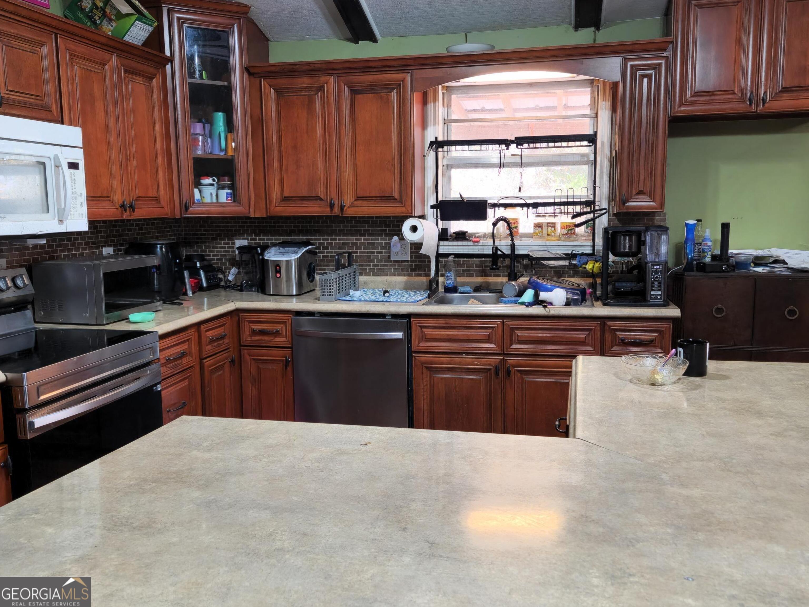 985 Frank Road Ocilla, GA 31774 - Photo 6 of 13 a kitchen with stainless steel appliances granite countertop a stove sink and cabinets