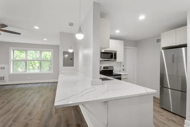 a kitchen with stainless steel appliances a refrigerator sink and microwave