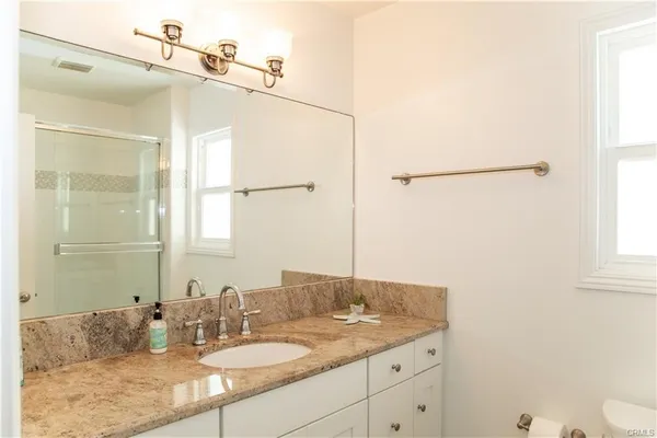 a bathroom with a granite countertop sink and a mirror