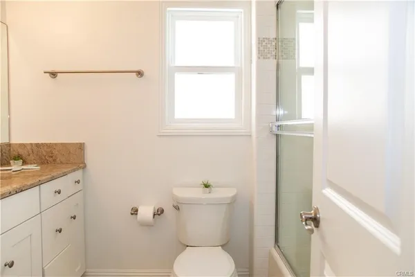 a bathroom with a toilet a sink and a window