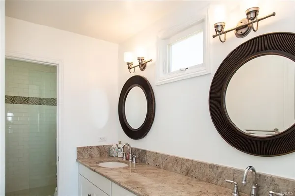 a bathroom with a granite countertop sink and a mirror