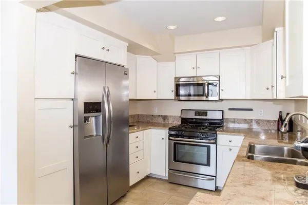 a kitchen with stainless steel appliances and white cabinets