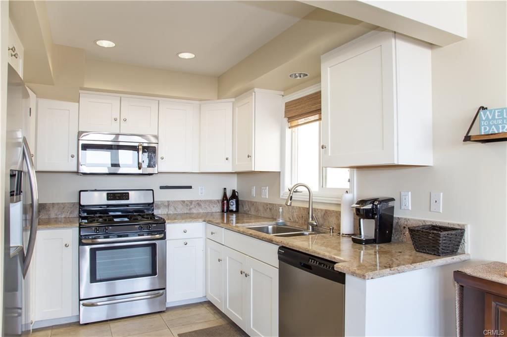 35 Surfside Avenue Surfside, CA 90743 - Photo 10 of 34 a kitchen with stainless steel appliances granite countertop a sink stove cabinets and refrigerator