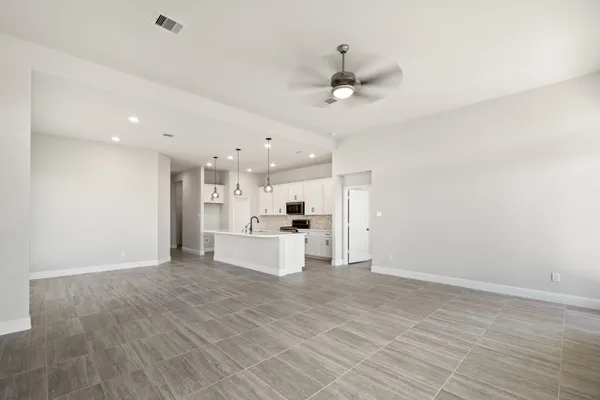 a living room with kitchen island furniture and a ceiling fan