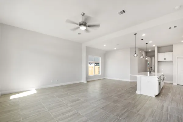 a view of an empty room with a kitchen