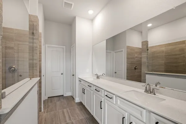 a spacious bathroom with double vanity and mirrors