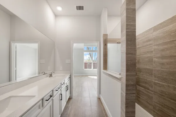 a bathroom with a double vanity sink and a mirror