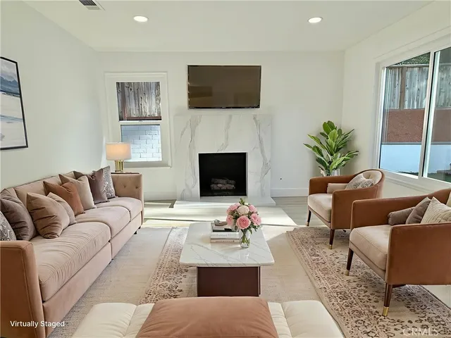 a view of an empty room with a fireplace and a window