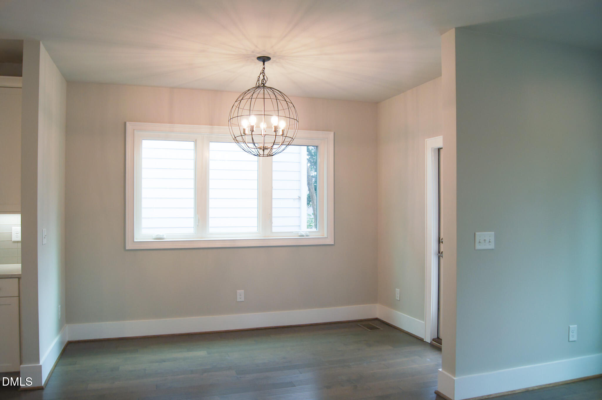 1208 Boyer Street Raleigh, NC 27610 - Photo 7 of 58 an empty room with wooden floor and chandelier