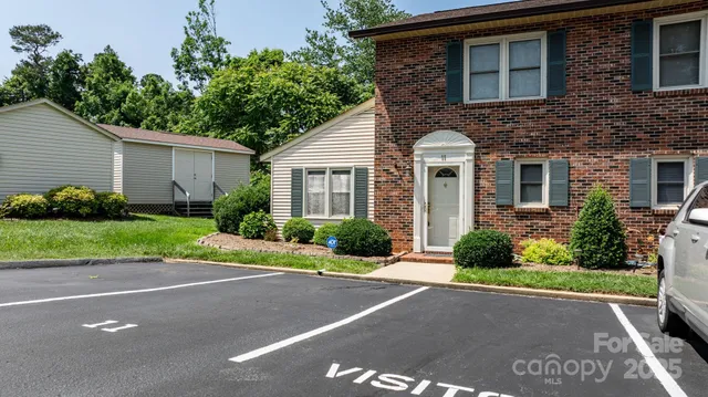 a front view of a house with a yard and potted plants