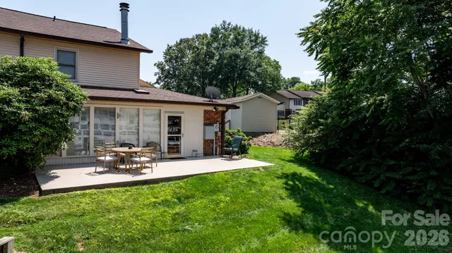 a view of backyard of house with outdoor seating and green space