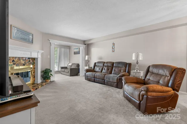 a living room with furniture a flat screen tv and a window
