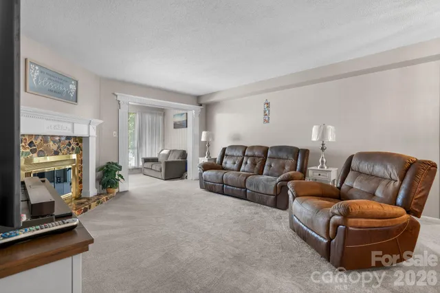 a living room with furniture a flat screen tv and a window