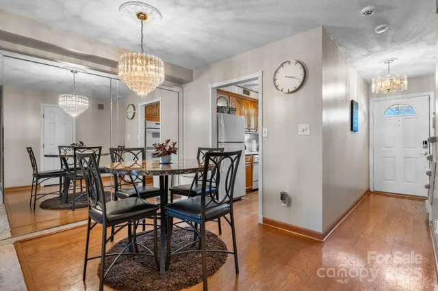 a view of a dining room with furniture a chandelier and wooden floor
