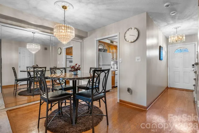 a view of a dining room with furniture a chandelier and wooden floor