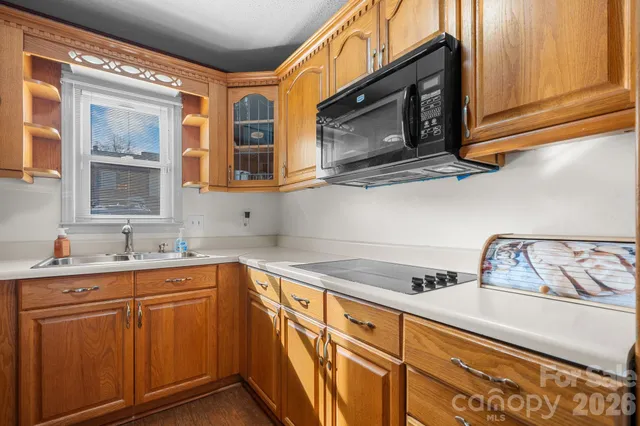 a kitchen with stainless steel appliances granite countertop a sink a stove and cabinets