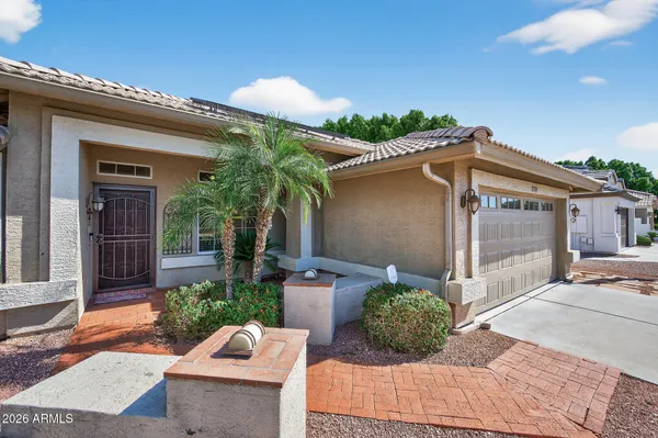 front view of a house with a large window and potted plants